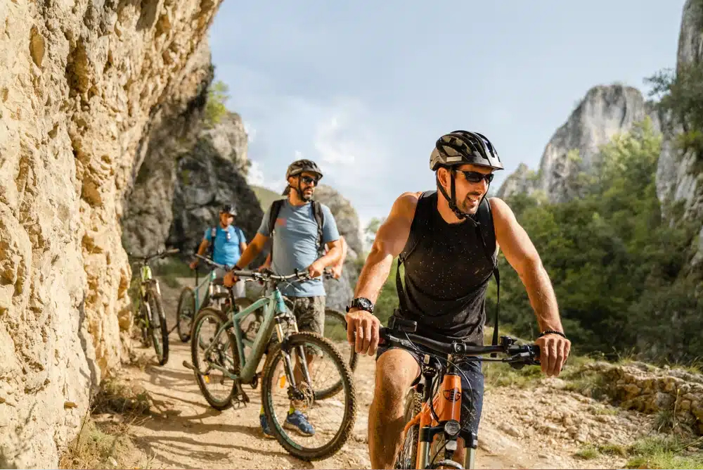 Ciclistas en un sendero irregular, ejemplificando estilos de vida activos que pueden provocar lesiones nasales y rinoplastia.
