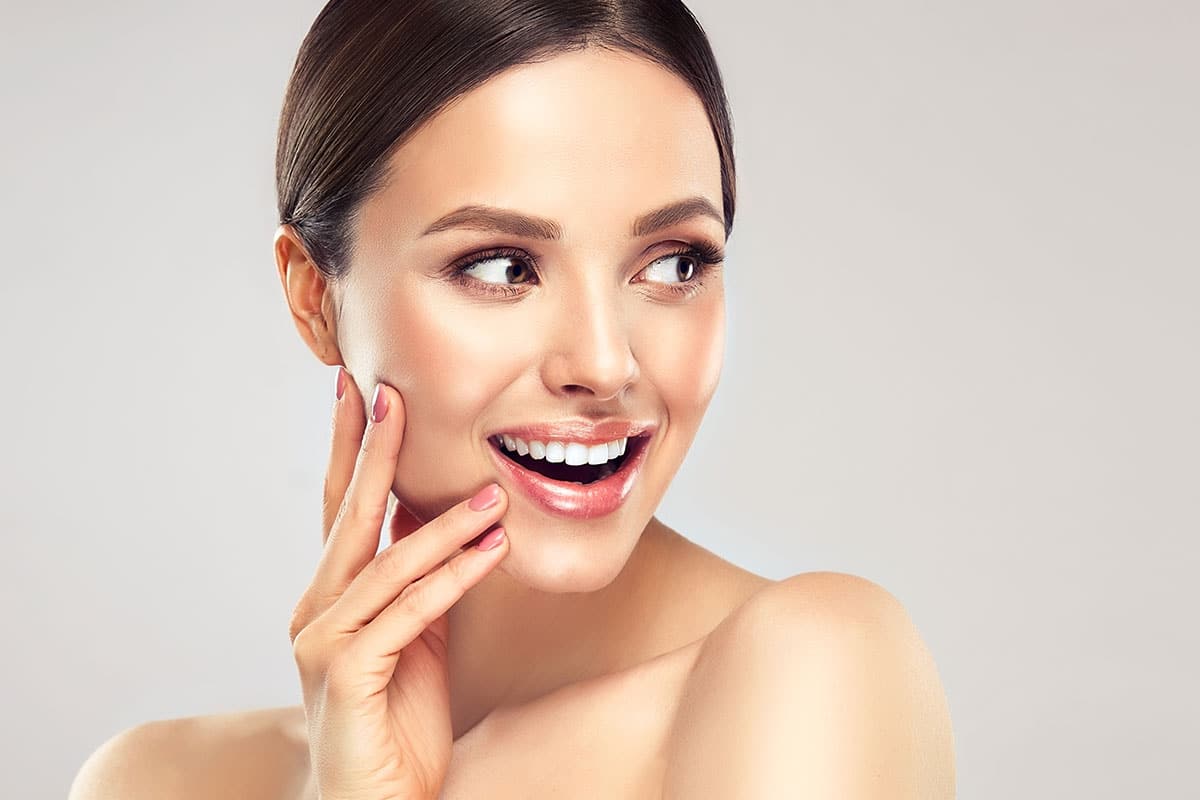 Mujer sonriente con rasgos juveniles y elevados que muestra resultados naturales de un procedimiento de lifting de plano profundo
