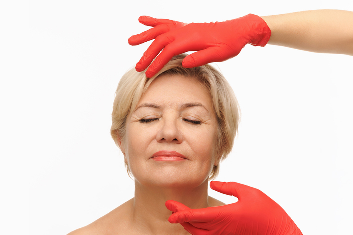 Mujer madura con los ojos cerrados recibiendo una evaluación facial antes de un lifting de plano profundo para un rejuvenecimiento duradero.