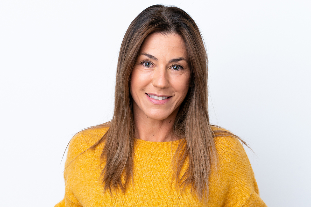 Mujer de mediana edad sonriendo con confianza tras un lifting facial con resultados naturales.